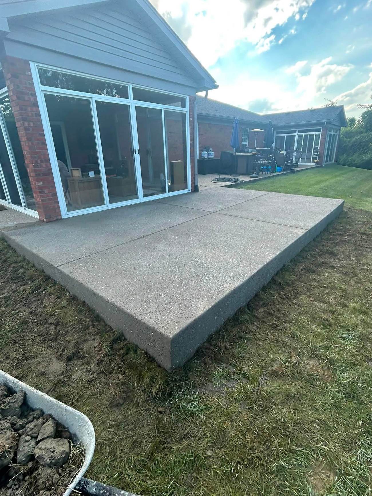 The same backyard space with a finished concrete patio slab