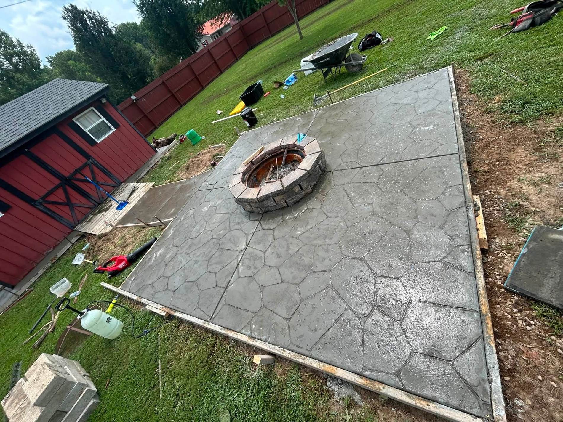 Decorative stamped concrete patio with a built-in stone fire pit