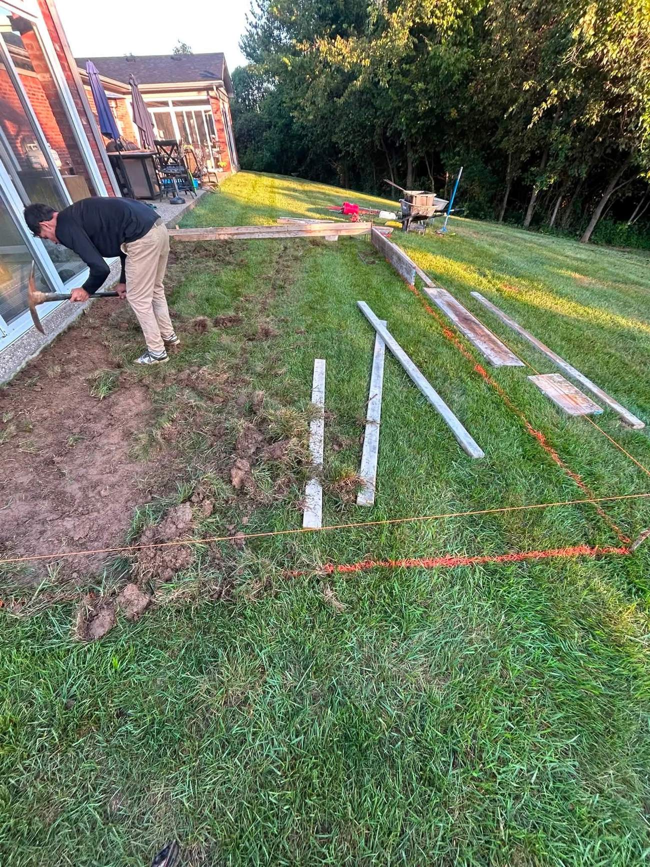 Ground preparation and layout lines for a backyard concrete project